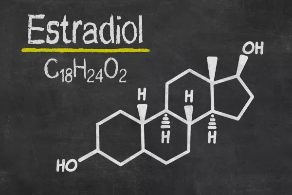 Quadro negro com representação química da molécula ilustrando a importância do estradiol para a FIV.