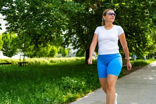Mulher caminhando ao ar livre representando estratégias de como emagrecer para engravidar na FIV.